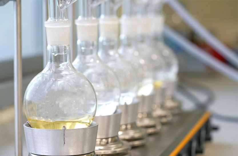 cat-labware-glassware A row of clear glass round bottom flasks.