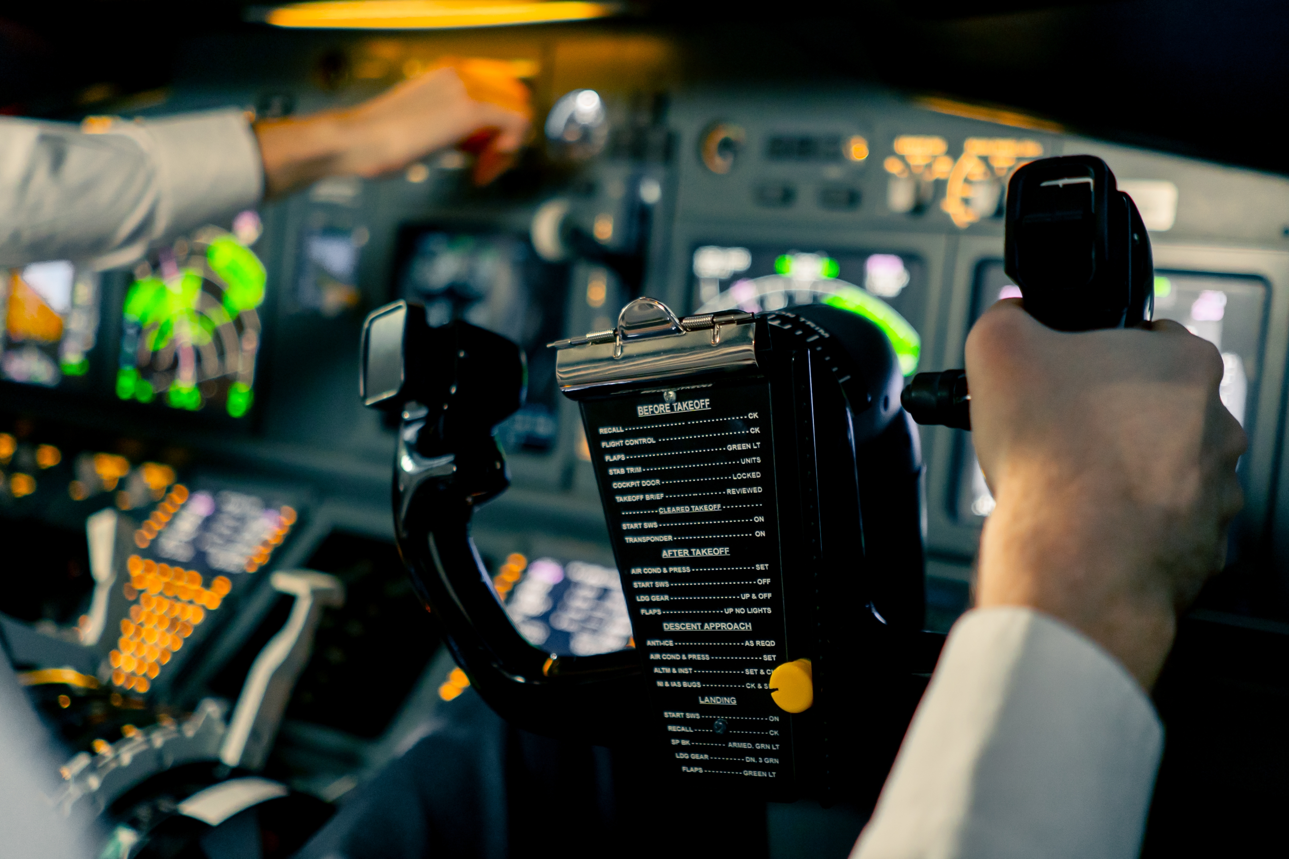 A pilot's hands holding the steering wheel in the cockpit of a plane.
