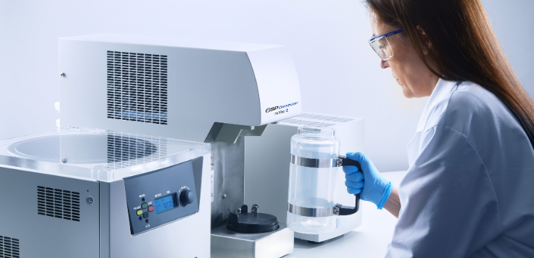 A scientist replacing the jar on the Genevac miVac Centrifugal Evaporator.