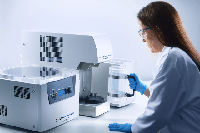 A scientist replacing the jar on the Genevac miVac Centrifugal Evaporator.
