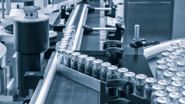 Glass vials being pushed by an autoloader into an aseptic freeze dryer.